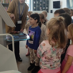 Pani Karolina uczy dzieci obsługi urządzenia do zwracania książek..jpg
