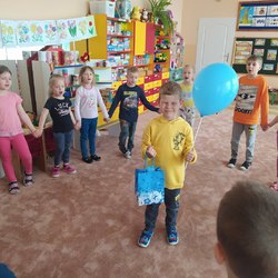chłopiec stoi w kole_ trzyma w ręce balonik.jpg