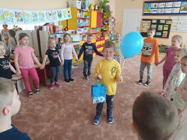 chłopiec stoi w kole_ trzyma w ręce balonik.jpg