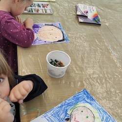 dzieci siedzą przy stole i maluja pastelami.jpg