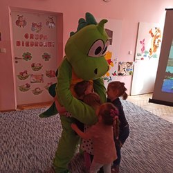 przedszkolaki przytulają się do dużego pluszowego dinozaura.jpg